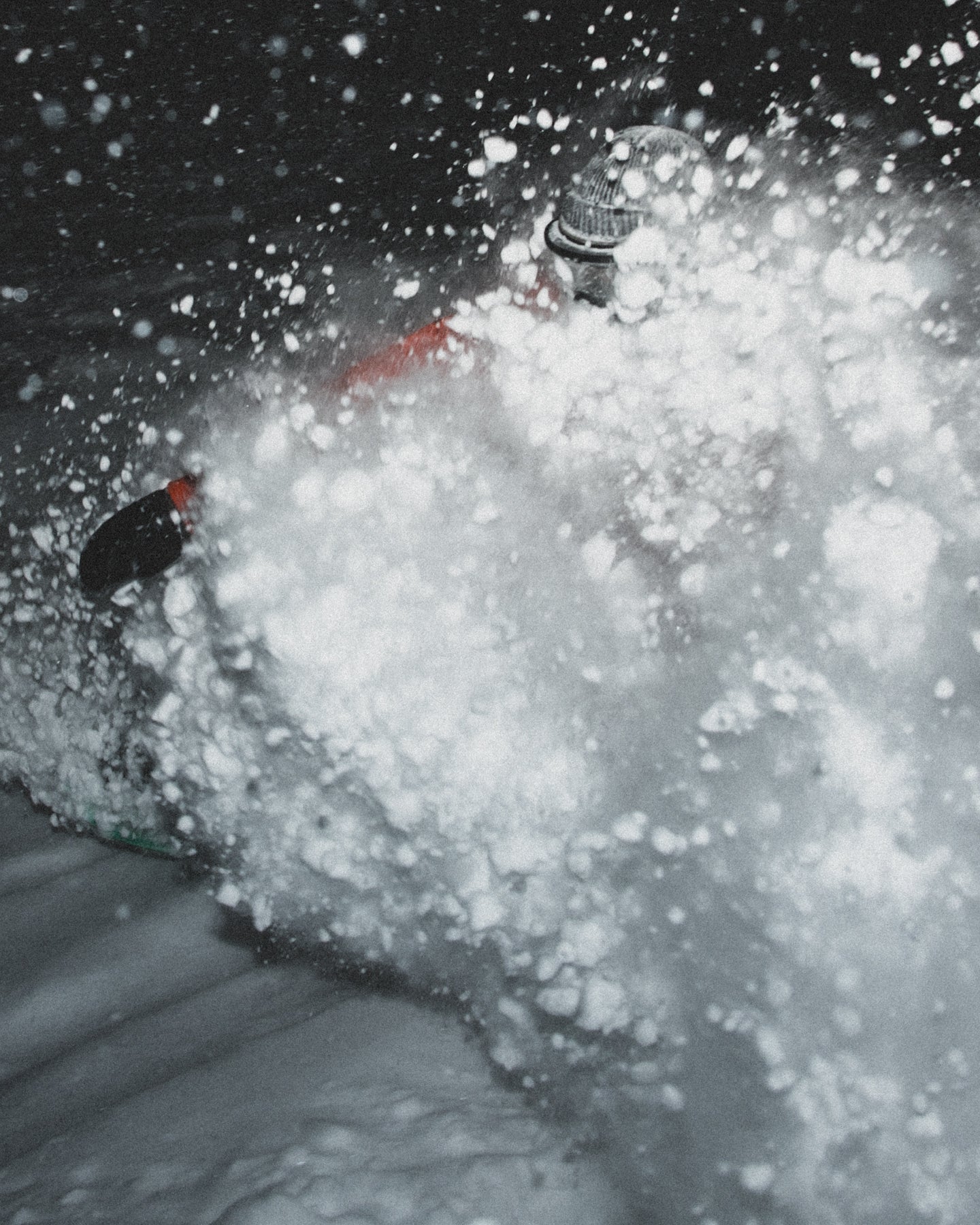 Person riding pow in a dark, snowy environment