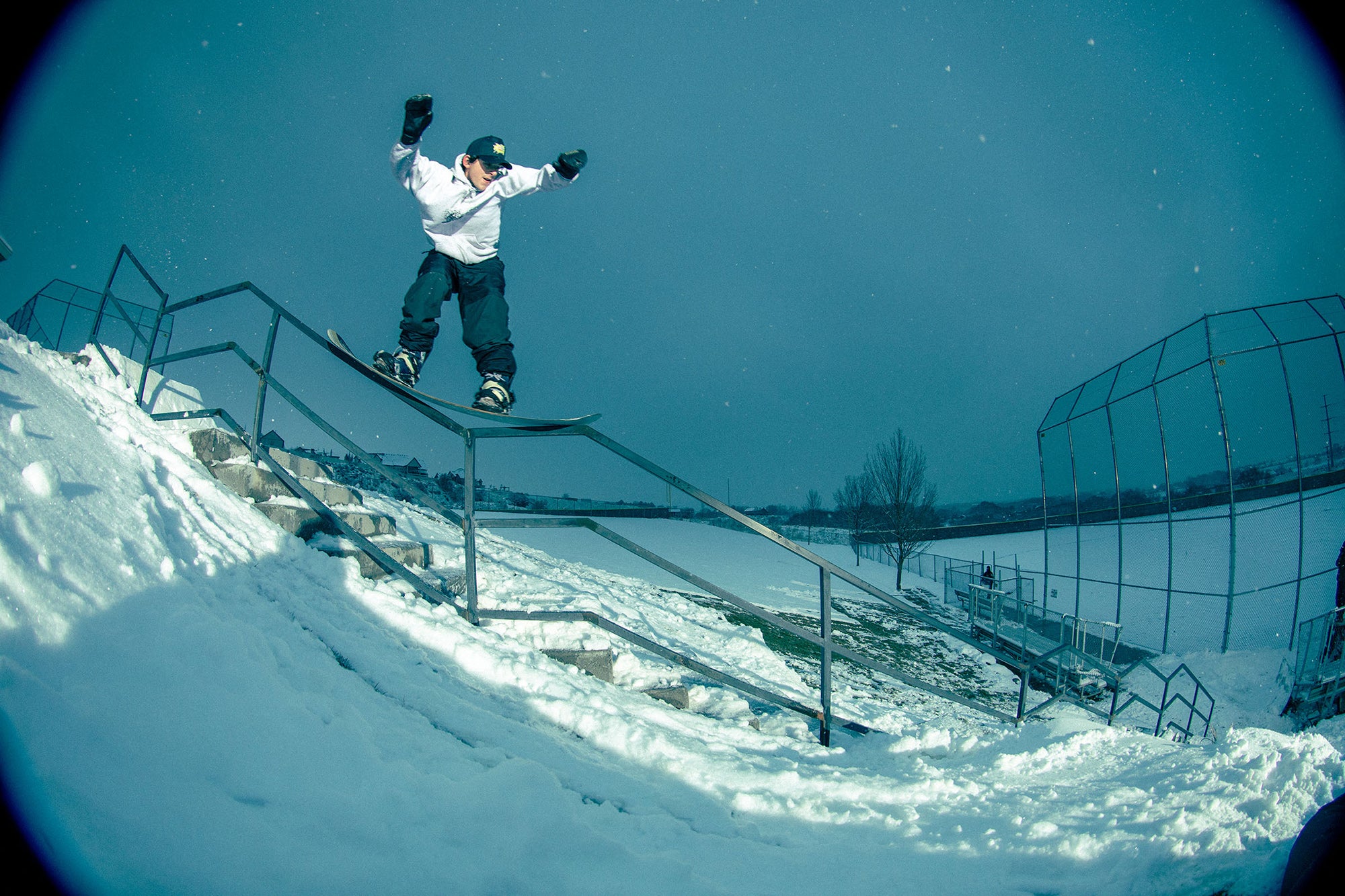 Caleb Kinnear 50-50 on a rail in a snowy outdoor setting