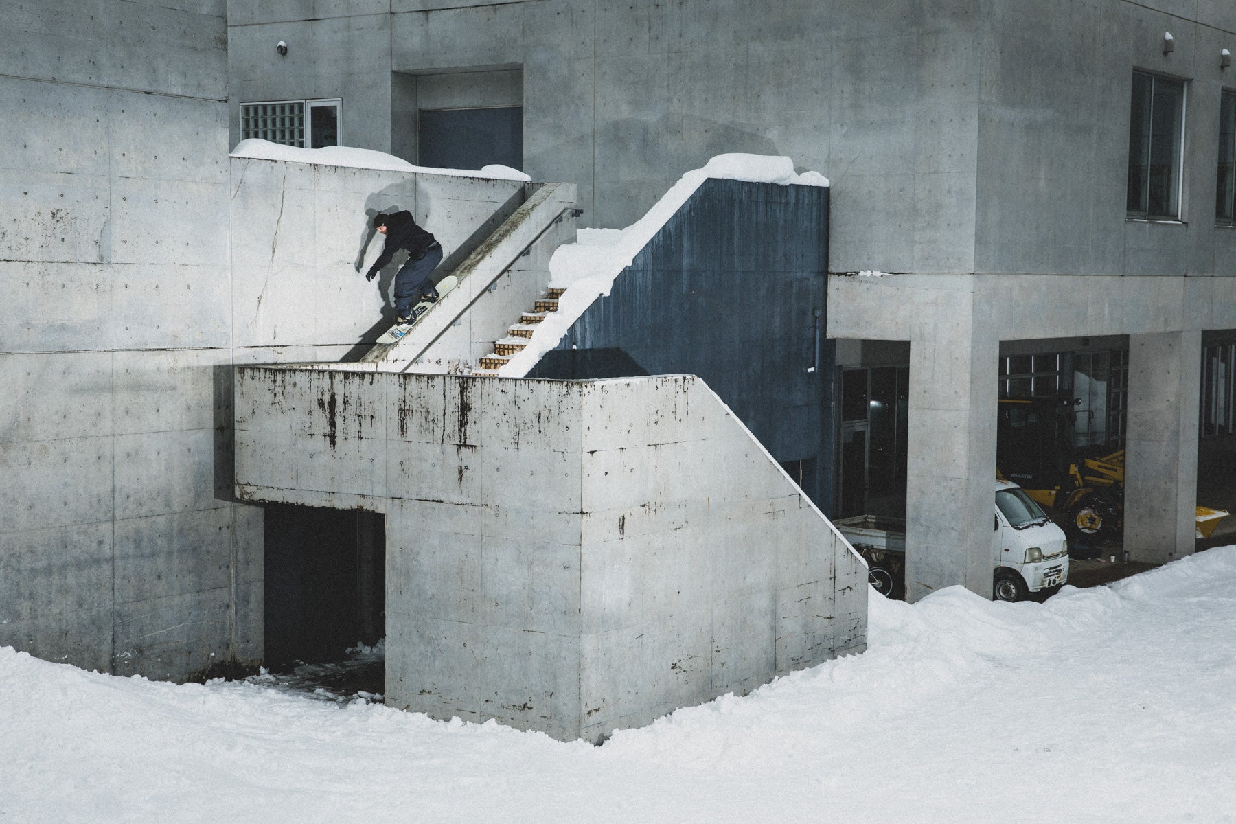 Dominik Wagner 50-50 on a staircase of a concrete building